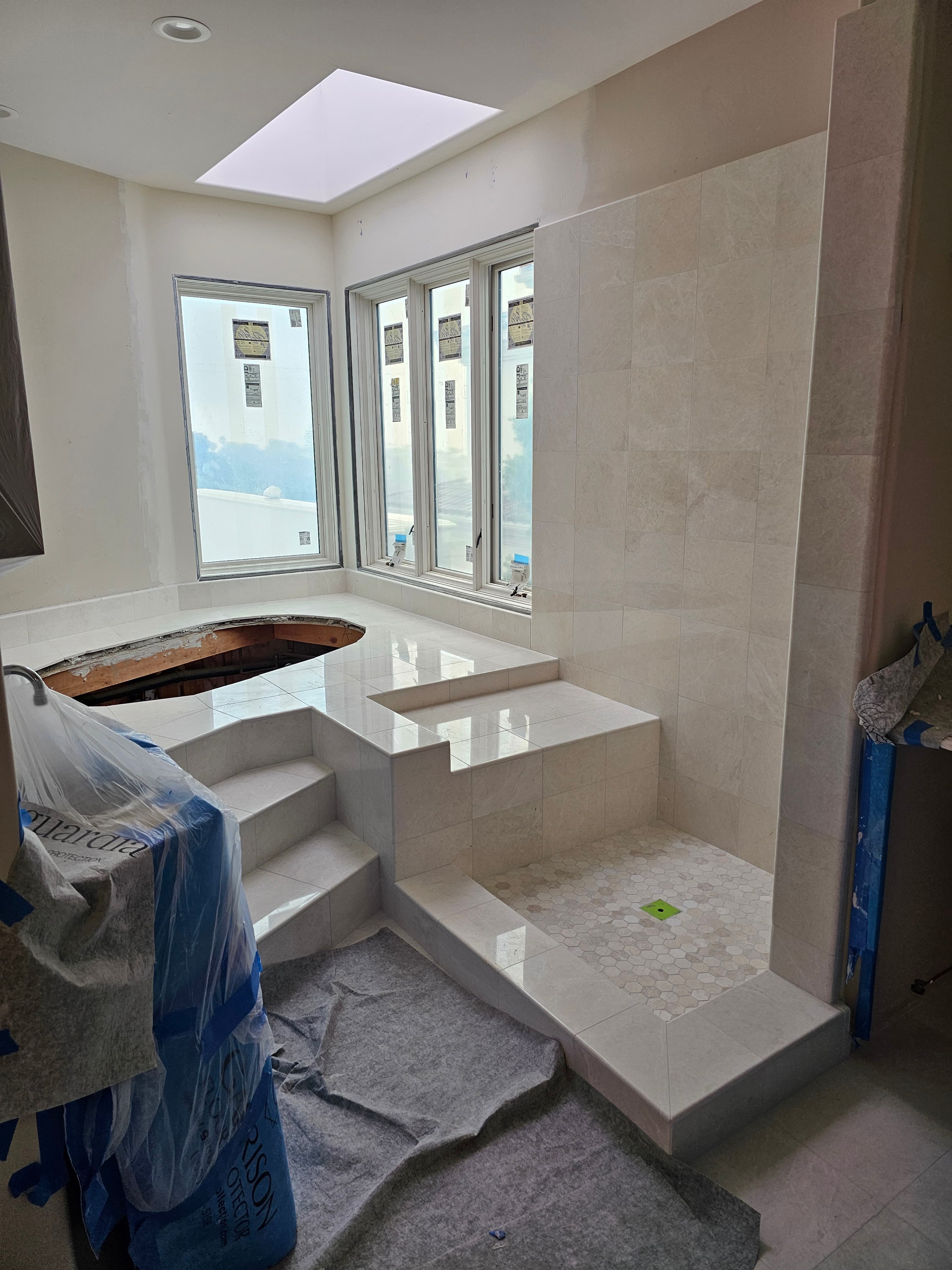 Elegant Carlsbad walk-in shower with seamless marble tile and decorative geometric accent wall