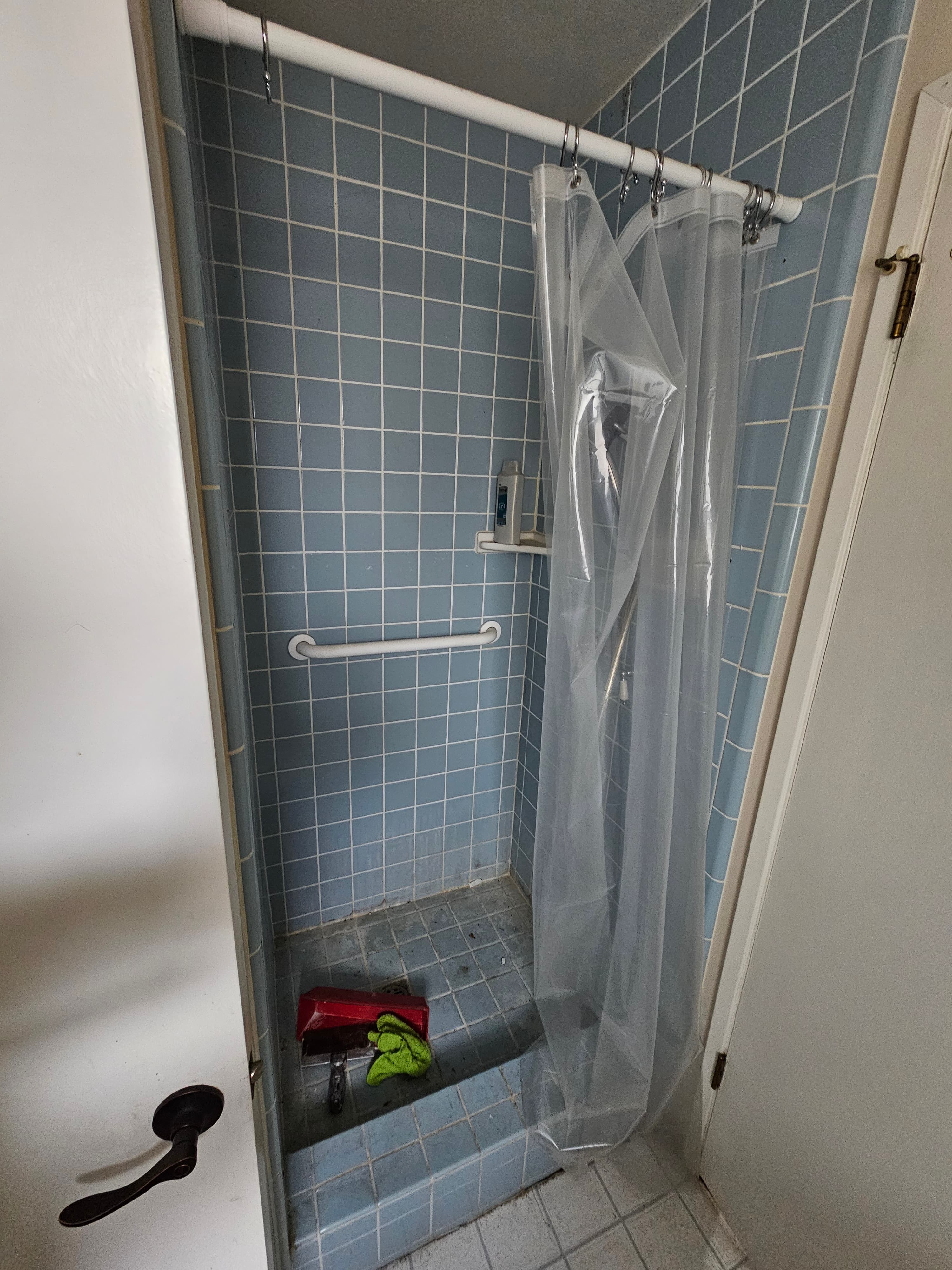 Worn blue subway tile shower in Orange, CA showing age and wear ahead of full transformation
